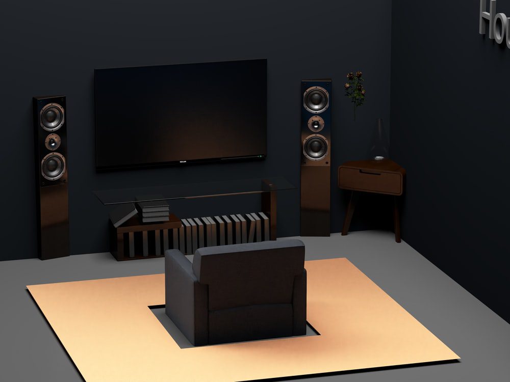 A Black Couch Overlooking a Matching Home Theater System Complete with Vertical Speakers