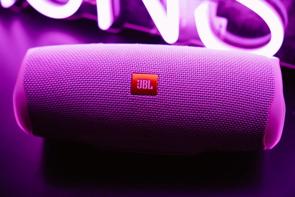 A Smart Bluetooth Speaker Against a Neon Purple Light